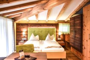 莱尔莫斯Hotel Lärchenhof的一间卧室配有一张带绿色床头板的床