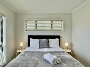 奥克兰Glendowie Brand-new comfortable 3 & 4-bedroom Houses的一间卧室配有一张大床和两盏灯