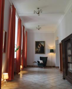康斯坦钦-耶焦尔纳Dobry Zakątek Dom Rekolekcyjny的客厅配有红色窗帘和椅子