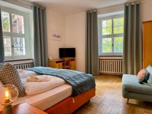 Kavaliershaus neben Schloss Rauenstein的一间卧室配有一张床、一张沙发和窗户。