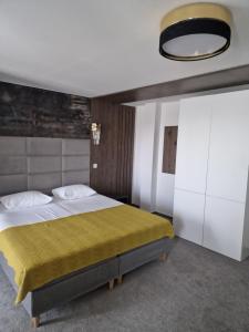加拉茨Hotel City Break的一间卧室配有一张带黄色毯子的大床