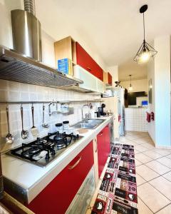 布拉恰诺La Corte del Principe的厨房配有红色橱柜和炉灶烤箱