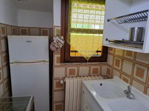 MagreglioMansardHouse zona Bellagio的厨房配有水槽、冰箱和窗户。