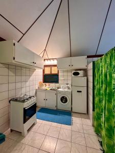 法勒« Le Green House » by Meri lodge Huahine的厨房配有白色橱柜、洗衣机和烘干机
