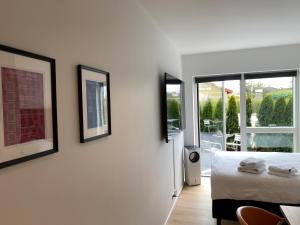 哥本哈根CPH Like Home的卧室配有一张床,墙上有三幅照片
