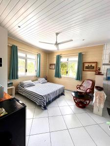 法勒Meri Lodge Huahine « ROOM OF MARTA »的一间卧室配有一张床和一把椅子