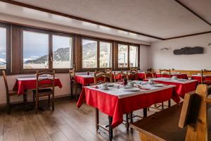 韦尔比耶圆厅酒店的餐厅配有桌椅和红色桌布