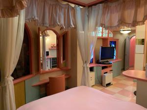 Iwakiriホテル　プレリュード的一间卧室配有一张带窗帘的床和电视。