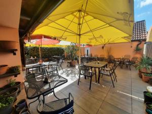 斯特日布罗燕麦旅馆的一个带桌椅和黄色遮阳伞的庭院