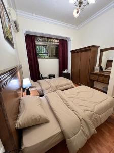 安曼苏富拉套房酒店的一间卧室设有两张床和窗户。