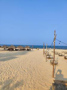 洞海View Nhat Le Beach Hotel的海滩上设有椅子和遮阳伞,还有大海