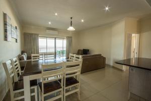 乌旺戈海滩Saints View Resort Unit 16的用餐室以及带桌椅的起居室。