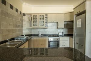 乌旺戈海滩Saints View Resort Unit 16的厨房配有白色橱柜和不锈钢用具