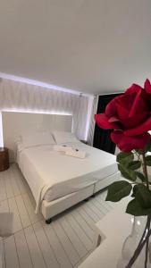 里米尼Q酒店的红色玫瑰间内的一张白色床