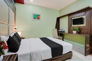 孟买Hotel New Blue Sapphire Residency的一间卧室配有一张床、一张书桌和一台电视