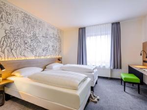 萨勒河畔哈雷哈雷宜必思尚品酒店的酒店客房,设有三张床和壁画