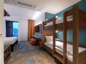 基尔ibis Styles Kiel City的一间卧室配有两张双层床和一张书桌