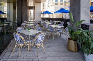 纳什维尔Tempo By Hilton Nashville Downtown的一个带桌椅和蓝伞的庭院