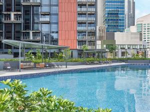 新加坡Mercure ICON Singapore City Centre的一座大型游泳池,位于部分建筑前