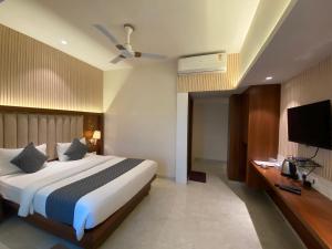 纳威孟买Hotel Czar Inn - Vashi Navi Mumbai的配有一张床和一台平面电视的酒店客房
