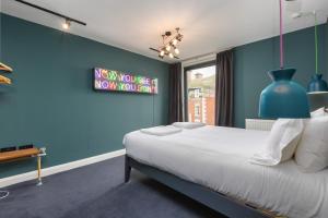 布莱克浦ART B&B的蓝色的卧室,配有床和蓝色的墙壁