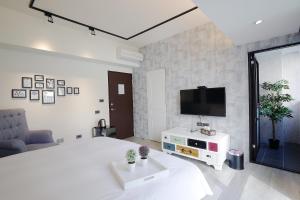 台中市悅柏行旅 逢甲館 YABO Inn的一间卧室配有一张床,墙上配有电视
