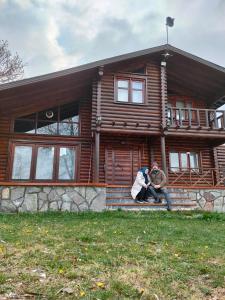 PiroğluChalet's lake_Bolu Abant _log house的两个人坐在木屋的台阶上