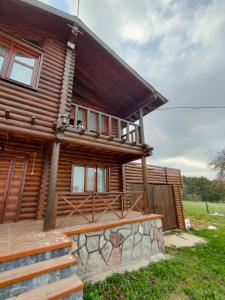 PiroğluChalet's lake_Bolu Abant _log house的小木屋设有门廊和通往小木屋的楼梯