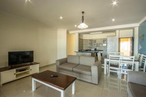 乌旺戈海滩Saints View Resort Unit 26的带沙发、电视和桌子的客厅