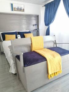 奇帕塔Ticia Apartment的一间卧室配有蓝色和黄色的毯子