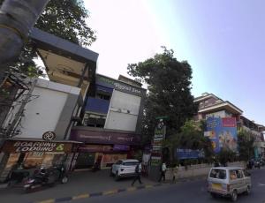 门格洛尔Hotel Royal Inn Mangalore - Opp SDM Law College MG Road的一条繁忙的城市街道上,街上有汽车停放