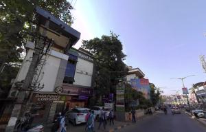 门格洛尔Hotel Royal Inn Mangalore - Opp SDM Law College MG Road的一条繁忙的城市街道,街上的人在街上行走