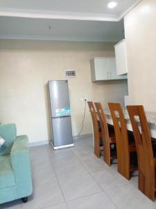 基加利Kigali Grand Villa的厨房配有冰箱和桌椅