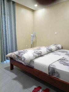 基加利Kigali Grand Villa的一间卧室配有两张床和风扇