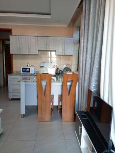 基加利Kigali Grand Villa的厨房配有带2把椅子和1张桌子的柜台