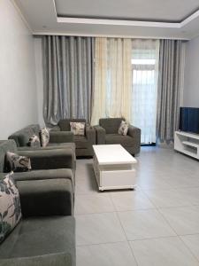 基加利Kigali Grand Villa的带沙发和电视的客厅