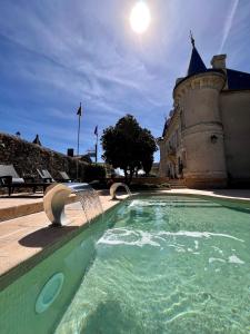 蒙帕齐耶Château Hôtel Edward 1er的一座建筑前的带喷泉的游泳池