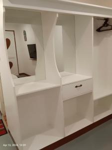 CamisanLoboc Nipa Huts Cottages Rental的客房内的白色橱柜和镜子
