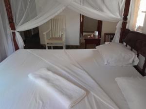 马林迪Lion Garden Villa 7的一张白色的床,上面有两条白色毛巾
