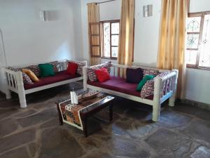 马林迪Lion Garden Villa 7的客厅配有两张沙发和一张桌子