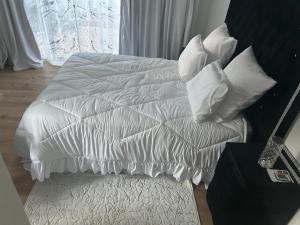SandtonUrban Fourways Haven的白色的床和白色枕头顶部