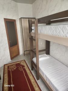 撒马尔罕Hostel Highway的一间设有两张双层床的房间,配有门和地毯