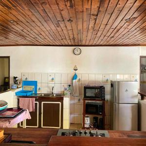 贝岛Villa Madirokely的厨房配有冰箱和墙上的时钟