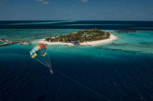 FushifaruFushifaru Maldives - 50 percent discount on transfers till 30 Sep 2024 on FB & AI for 04 nights or above的海岛上空降落伞的人