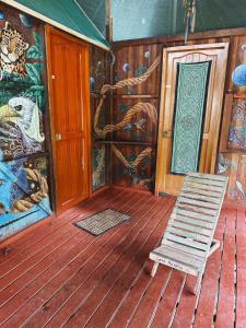 普卡尔帕Jungle Lodge with lookout tower的木甲板上的摇椅,壁画