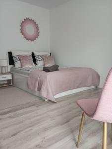 波拉齐克Noclegi U Janusza 536-310-384的一间卧室配有一张床和一张粉红色的椅子