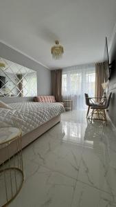 索波特Gold Glamour Apartment Sopot z dwoma sypialniami, duzy balkon的卧室配有1张床、1张桌子和1把椅子