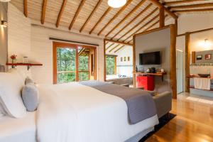 贡萨尔维斯Pousada Casa Campestre的卧室配有一张白色大床和电视。