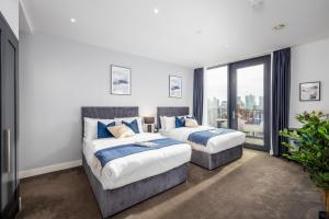 伦敦Luxury & Spacious 2 BR APT with City Views的带窗户的客房内的两张床