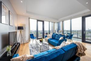 伦敦Luxury & Spacious 2 BR APT with City Views的客厅设有蓝色的沙发和大窗户